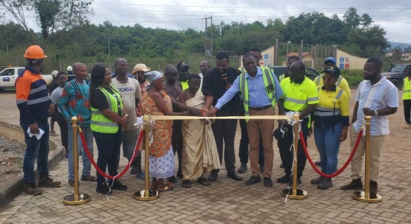 Mr Baidoo (4th right) being assisted by together Mr Adansi Bonah, MCE of Obuasi together with the traditional authorities of Nhyieso commissioning the road.