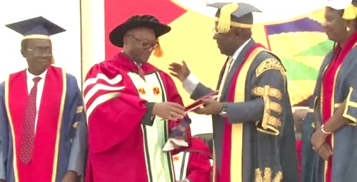 Prof. Akyeampong (2nd from left) being handed his honorary doctorate degree after he was robed by Sir Sam Jonah, the Chancellor of UCC