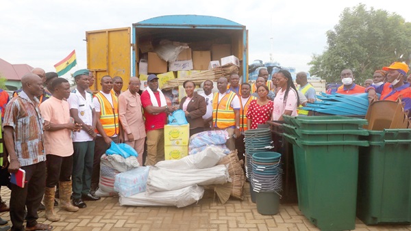 Gloria Opoku-Anti (arrowed) presenting the items to Seji Saji Amedonu while Divine Fenu (6th from left), the DCE, and some officials of both Zoomlion and the district assembly look on. Picture: DELLA RUSSEL OCLOO Gloria Opoku-Anti (arrowed) presenting the items to Seji Saji Amedonu while Divine Fenu (6th from left), the DCE, and some officials of both Zoomlion and the district assembly look on. Picture: DELLA RUSSEL OCLOO