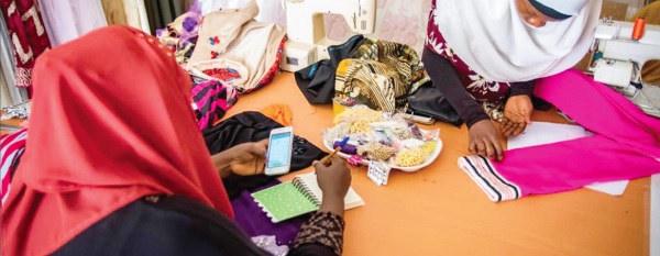 A fashion designer conducting a transaction on a mobile phone