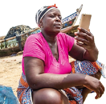 A fishmonger using her mobile phone at the beach after sourcing fish