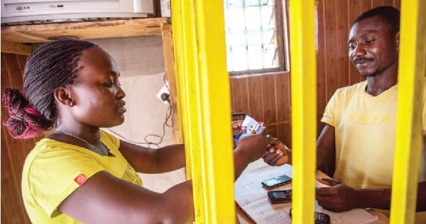 A woman engaging in a mobile money (momo) transaction with an agent