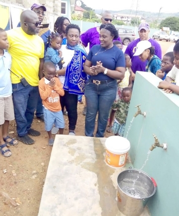 Nana Ama Owusu, Executive Director of Potter’s Village, and others looking on as the water flows Nana Ama Owusu, Executive Director of Potter’s Village, and others looking on as the water flows