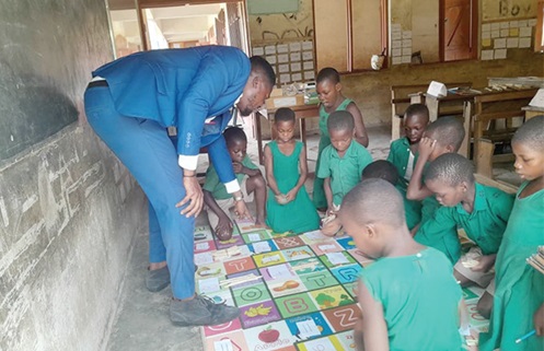 William Edward (left), a teacher of the EP Primary at Donkorkrom, taking  Mathematics  Level two learners through differentiated learning