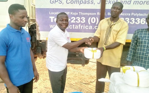 Gyekwe Twum Ampofo (middle), Procurement Manager of CCT, and Samuel Tulasi (left), Warehouse Officer of the company, presenting the items to one of the fishermen Gyekwe Twum Ampofo (middle), Procurement Manager of CCT, and Samuel Tulasi (left), Warehouse Officer of the company, presenting the items to one of the fishermen