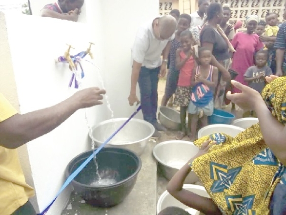 Ebenezer Asiedu Okyere, representative of Father Sam Charities, cutting a ribbon to inaugurate the water project at Ashilfa Ebenezer Asiedu Okyere, representative of Father Sam Charities, cutting a ribbon to inaugurate the water project at Ashilfa