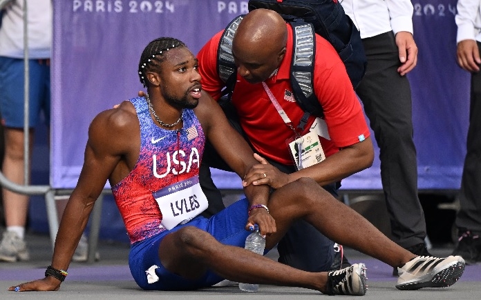 Noah Lyles receives medical attention after the men's 200m final at Stade de France