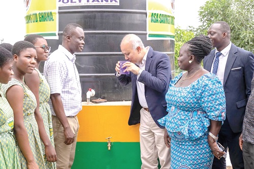 Mohammed Aourongjeb (3rd from right), Chief Executive Officer of ASA Savings and Loans Limited, drinking the water after inauguration while Benjamin Okai Sakyi (4th from left), Headmaster of Asamankese Senior High School, as well as students looks on Mohammed Aourongjeb (3rd from right), Chief Executive Officer of ASA Savings and Loans Limited, drinking the water after inauguration while Benjamin Okai Sakyi (4th from left), Headmaster of Asamankese Senior High School, as well as students looks on