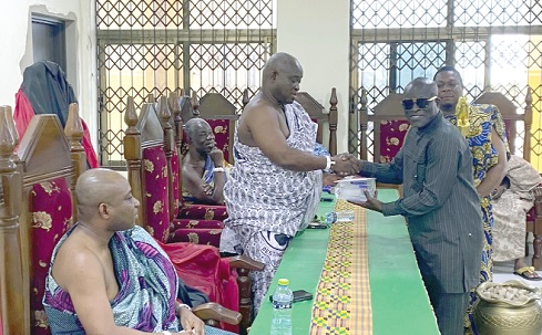 Daniel Nii Kwartei Titus-Glover (right), Greater Accra Regional Minister, presenting a box of Castle Bridge to Nii Obodai Adai IV, La Mankralo. Seated left is Nii Adjei Kofeh IV, La Shikitele of the La Traditional Council