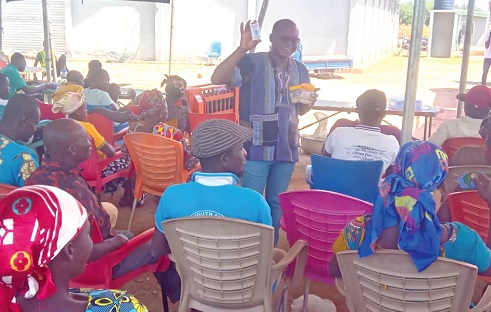 Nelson Gulbi, an Agronomist at SNV, explaining the use of the dry card to the farmers during the training