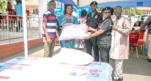 Gifty Appiah (2nd from left), PRO, Latex Foam, handing over the items to Under Cadet Sgt. Emmanuel Azure (middle), being supported by C. Supt. Rosina A. D. Gariba, an officer at the National Police Training School in Accra. With them are other officials of Latex Foam Gifty Appiah (2nd from left), PRO, Latex Foam, handing over the items to Under Cadet Sgt. Emmanuel Azure (middle), being supported by C. Supt. Rosina A. D. Gariba, an officer at the National Police Training School in Accra. With them are other officials of Latex Foam