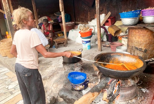 One of the caterers at Kenkey house stirring pepper sauce One of the caterers at Kenkey house stirring pepper sauce