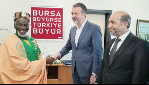Cuneyt Sener, the Vice-President of the Chamber, presenting a souvenir to the Ya-Na. Looking on is a Board Member of the Bursa Chamber of Commerce Cuneyt Sener, the Vice-President of the Chamber, presenting a souvenir to the Ya-Na. Looking on is a Board Member of the Bursa Chamber of Commerce