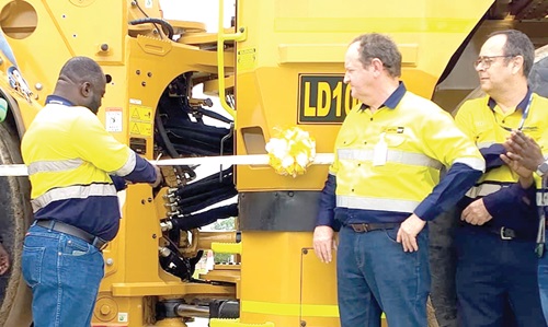 The diesel-electric loader. inset: Alex Kofi Annin (left), General Manager of the Ahafo South Mine, cutting the tape to unveil the diesel-electric loader. With him is Steven Scott (2nd from right), Managing Director of Mantrac Ghana The diesel-electric loader. inset: Alex Kofi Annin (left), General Manager of the Ahafo South Mine, cutting the tape to unveil the diesel-electric loader. With him is Steven Scott (2nd from right), Managing Director of Mantrac Ghana