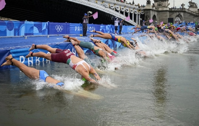 Athletes dived into the water for the start of the women's individual triathlon event Athletes dived into the water for the start of the women's individual triathlon event