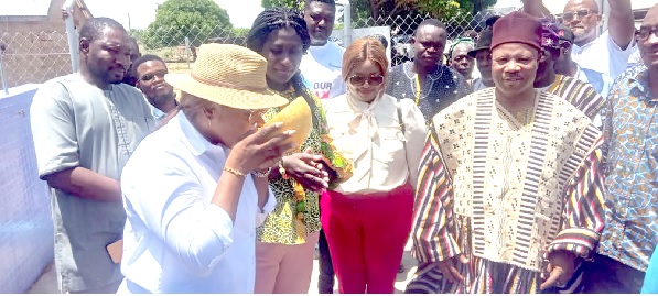 Felicite Nson (left), Managing Director,GGBL, drinking some of the water in a calabash after commissioning the water project, while other officials look on