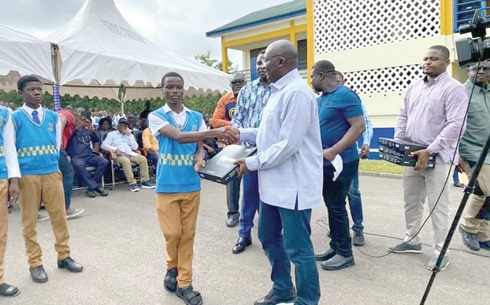Dr Bawumia presenting a tablet to one of the students