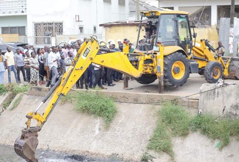  Kojo Oppong-Nkrumah (inset), Minister of Works and Housing, breaking the ground for the commencement of work