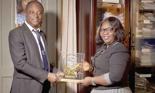  Bright Mensah Amankwah (left), HR Manager of the bank, presenting the award to Lucy Opoku-Arthur, CEO, Kwahu Praso Rural Bank