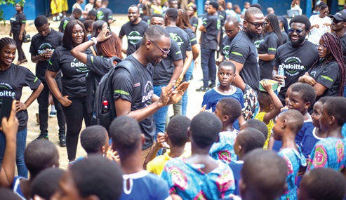 Some of the staff of Deloitte Ghana assisting children
