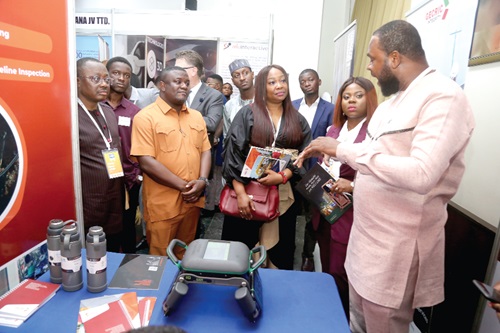 Gilbert Asase (right), Chief Executive Officer, GECRIC Integrity, briefing Collins Adomako Mensah (2nd from left), a Deputy Minister of Energy, at an exhibition at the SPE Biennial Summit in Accra. With them are guests at the ceremony. Picture: SAMUEL TEI ADANO