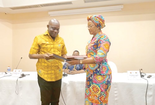 Major-General Dr Emmanuel Kotia (left) exchanging the signed documents with Salimata Dabal, Permanent Secretary, Burkina Faso Boundary Commission 