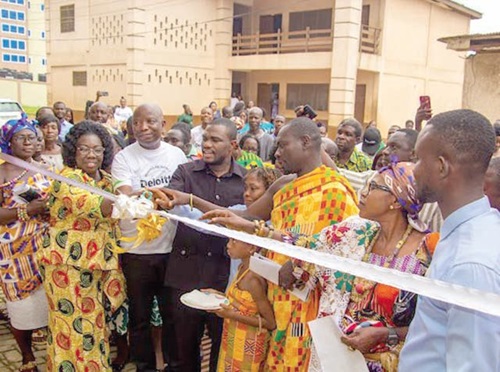 Dr Eric Nkansah (arrowed) being assisted to cut the tape to officially inaugurate the library Dr Eric Nkansah (arrowed) being assisted to cut the tape to officially inaugurate the library