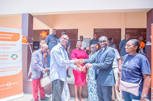 Simon Adu-Gyamfi (2nd from right), Director, Banking Operations of Fidelity Bank, handing over the classroom keys to Enoch Anyingmor Teye, Head teacher, Abbeykope D/A Basic school