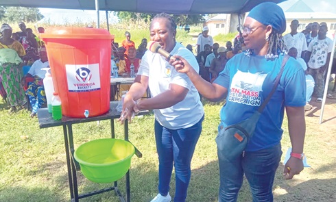 Eunice Tangwam, a public health nurse, demonstrating proper handwashing to the residents of Manyoro during the event