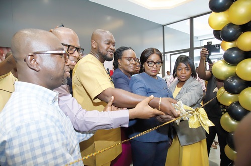 Nana Akwasi Awuah (middle), Managing Director, PMMC, cutting the ribbon to open the shop, while other officials of PMMC look on Nana Akwasi Awuah (middle), Managing Director, PMMC, cutting the ribbon to open the shop, while other officials of PMMC look on