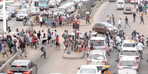Pedestrians crossing the Madina Zongo Junction road through an unapproved route despite the availability of a footbridge 