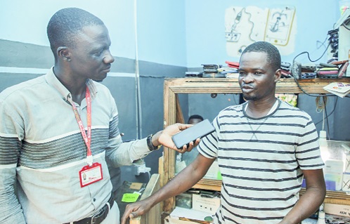 Our reporter speaking to Simon Ntemor (right), Phone Repairer, concerning the constituency 