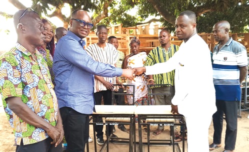 John Nkaw (2nd from left), Country Director of ActionAid Ghana, handing over the desks to Frederick Yirkyio (right), Deputy Tain District Coordinating Director John Nkaw (2nd from left), Country Director of ActionAid Ghana, handing over the desks to Frederick Yirkyio (right), Deputy Tain District Coordinating Director