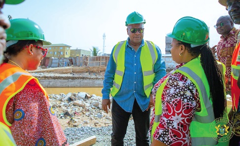 President Mahama conferring with Linda Ocloo (left), Greater Accra Regional Minister, and Theresa Awuni (right), MP for Okaikwei North Constituency, during the inspection of the Achimota storm drain