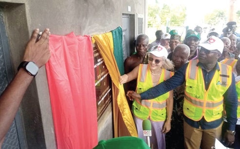 John A. Jinapor (right), Minister of Energy and Green Transition, assisted by Simone Giger, the Swiss Ambassador to Ghana, to unveil a plaque to inaugurate the mini grid system at Aflivie