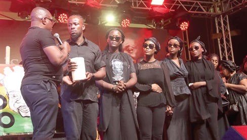 Wakefield Akuaku (left), Executive Director, National Commission on Culture, presents a commemorative candle to Kelvin Fosu, son of the late Daddy Lumba, on behalf of the President.  Picture: ELVIS NII NOI DOWUONA