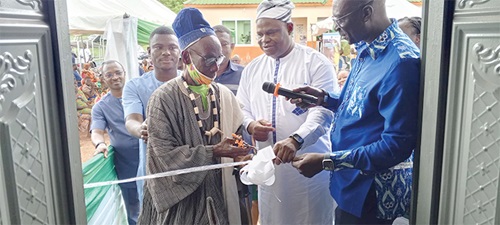 The renovated Nangodi Health Centre. INSET: Naab Sapaat Namalteng, the Chief of Tongo, being assisted by Dr Braimah Baba Abubakari (middle), the Regional Director of Health Services, to cut the tape to inaugurate the facility