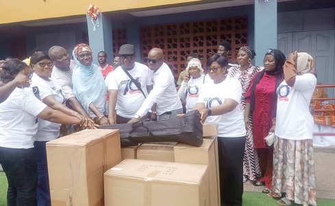 Dr Fatimatu Sulemanu (4th from left), Lecturer at the Department of Religion Studies at the University of Ghana, Legon, and other old students presenting some musical instruments to the management members of the Mount Zion Basic School.