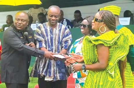 Anastasia Afua Konadu (arrowed), Headmistress of  Ebenezer SHS, receiving a parcel from Rev. Dr Kweku Addo