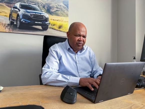 Isuzu Motors South Africa President and CEO Billy Tom works on his laptop at Isuzu's distribution facility in Gqeberha, South Africa, August 15, 2025. REUTERS/Nqobile Dludla