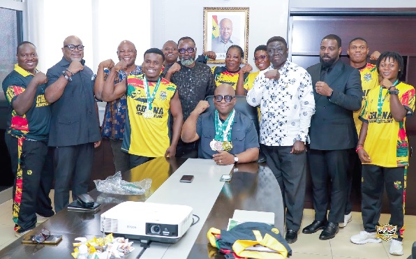 • Dr Victor Bampoe (seated) proudly wears some of the medals won by the Golden Arms during the team’s visit • Dr Victor Bampoe (seated) proudly wears some of the medals won by the Golden Arms during the team’s visit