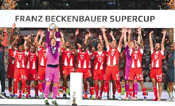 •  Bayern Munich skipper Manuel Neuer hoists the Super Cup aloft as his jubilant teammates erupt in celebration