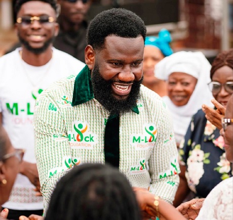 Michael Danquah, President of M-Lock Foundation, dancing with some of the widows