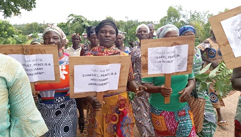 Women with their placards with messages about peace during the walk Women with their placards with messages about peace during the walk