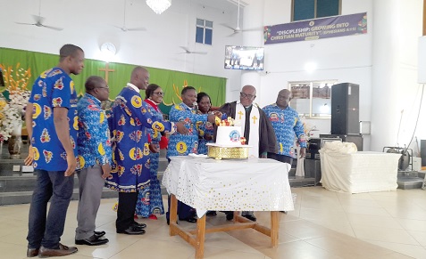Very Rev. James Kwakye (4th from right), Superintendent Minister of New Aplaku Circuit of the Methodist Church Ghana, being assisted by other dignitaries to cut the anniversary cake