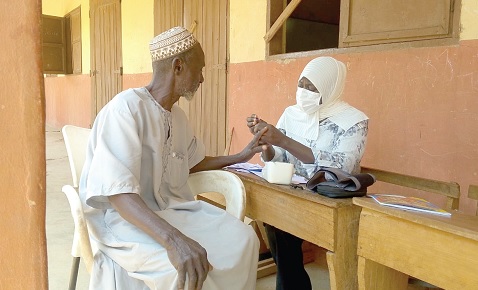 A nurse (right) attending to a beneficiary