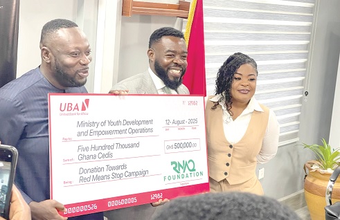 George Opare Addo (left), Minister of Youth Development and Empowerment, receiving a cheque from Richard Nii Armah Quaye (middle), Founder and chairperson of the organisation