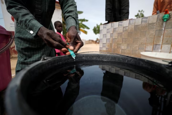 A community health worker adds chlorine to water while internally displaced people gather to fill their buckets at the water point in Muna Garage IDP camp in Maiduguri, Borno State, Nigeria October 23, 2022. REUTERS/Christophe Van Der Perre/File Photo A community health worker adds chlorine to water while internally displaced people gather to fill their buckets at the water point in Muna Garage IDP camp in Maiduguri, Borno State, Nigeria October 23, 2022. REUTERS/Christophe Van Der Perre/File Photo