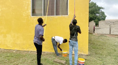 Some members of the church painting the buildings of the Asene Health Centre.