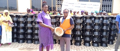 Samuel Abasiba (right), an official of the FMNR Project, World Vision Ghana, handing over the stoves to Mbila Martha, spokesperson of the women